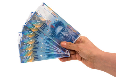 Hand holding banknotes of 100 swiss franc isolated on white background with clipping pathの写真素材