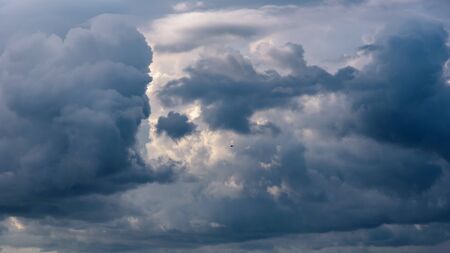 Natural background made of dark stormy cumulus clouds at sunsetの写真素材
