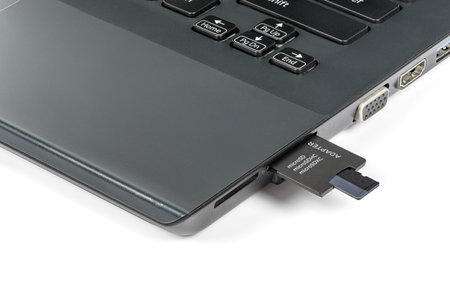 Memory card inserting into adapter and laptops card reader isolated on white background