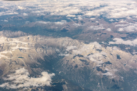 Clouds above the peaks of Alps mountains on a sunny dayの写真素材