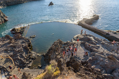 Acantilado de Los Gigantes, Tenerife, Spain: September 21, 2022: People sunbath at the natural swimming pool of Acantilado de Los Gigantes, famous tourist location at Tenerife islandのeditorial素材