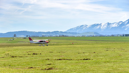 Small airplane on the sport grass airfield in Nowy Targ. Tatra mountain in the background.