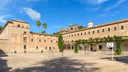 The Lluc sanctuary in Mallorca features a historic courtyard with an old monastery building and a sports area. Balearic Islands, Spainの写真素材