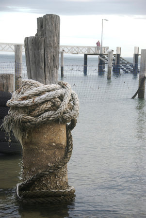 Mooring rope wrapped around post in a marinaの写真素材