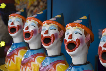 Stock photo of a row of plastic clown heads in a midway booth