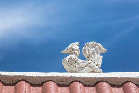 White bird lai thai statue stay on the roof of public location lampoon thailand temple with beautiful blue sky backgroundの写真素材