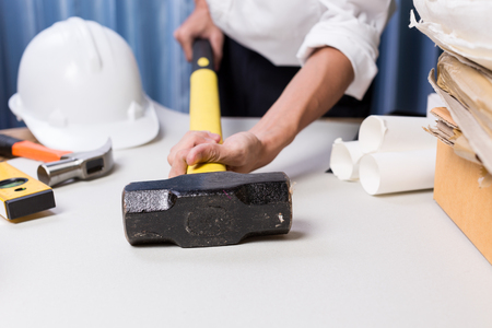 Business man engineering working on the desk, Quality inspection on hammer to use in building construction project with paperwork and engineering tools on working desk.の写真素材