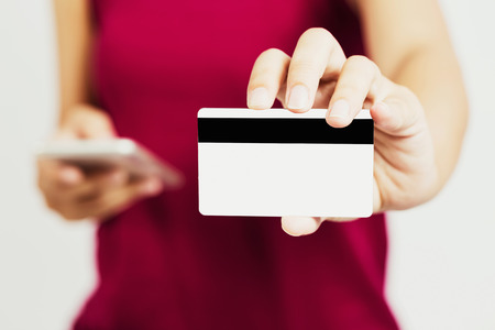 Young asian girl using her cellphone for buying clothes by mobile app in relax time, retro picture tone.の写真素材
