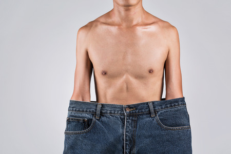 A man in bigger jeans with thin body, asian man in studio photography.の写真素材