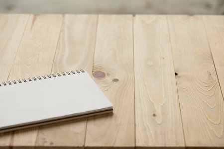 Modern working place paper book on vintage wood table close up, copy spaceの写真素材