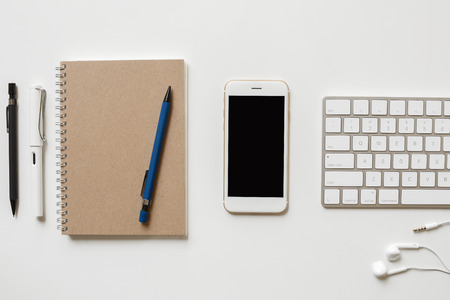 Office table with computer keyboard, notepaper, pen and smartphone. copy spaceの写真素材