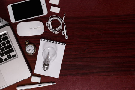 Top view of business elements & IT gadgets display on hard wood office, flat lay of business equipment in workplace, still life business concept.の写真素材