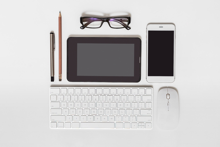 Flat lay of business equipment and accessories row display on wooden tablet white background.の写真素材