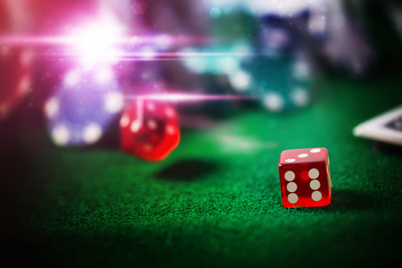 Red Dice Casino on green floor with blurry gambling coin abstract glitter background, dark tone.の写真素材