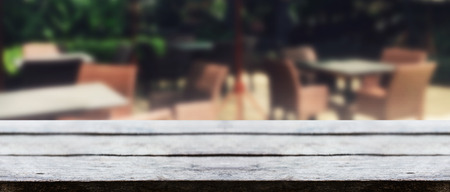 Panorama vintage wooden tabletop with blurry coffee shop sofa for montage display your product.の写真素材