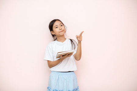 Asian tanned skin girl child portrait over pink wall background.の写真素材