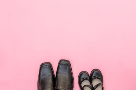 Top view daddy boots with daughter girl child on pink background.の写真素材