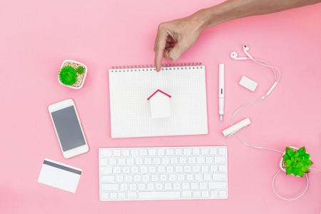 Top view business objects with man hand on sweet pink background, protect your house property concept.の写真素材
