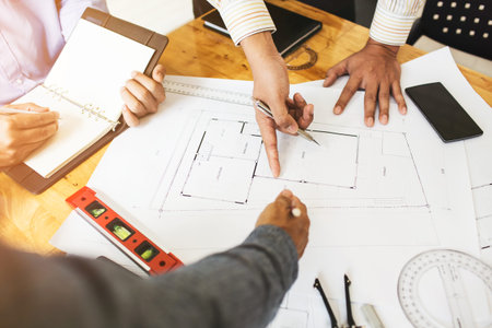 Consultation between colleagues, engineering team to check the blueprint used to build commercial...