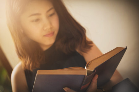 Asian woman reading a book with vintage clothing jeans style old background.