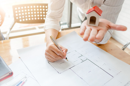Business architect engineer drawing a house blueprint planning to build a new home at housing estate development project.の写真素材