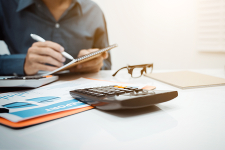 Young business man inspector in financial report of secretary making and counting calculator in office at home.の写真素材