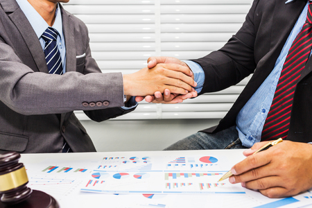 A handshake between a lawyer and a male office worker. To agree to employment In consultation with real estate trading law.の写真素材
