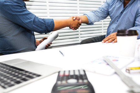 Shaking hands of engineers and contractors to sign a contract to build a house.