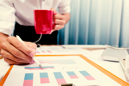 Successful project with business man working hard on financial charts in the office workplace.の写真素材