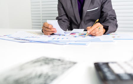 The 55 years old female businesswoman is calculating absorbed cost.の写真素材