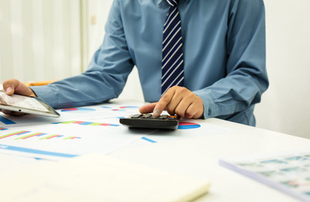 Businessman using a personal income tax calculator. To send information to the Revenue.