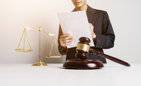 Real estate insurance lawyer working hard job, signing a contract with wooden house model.の写真素材