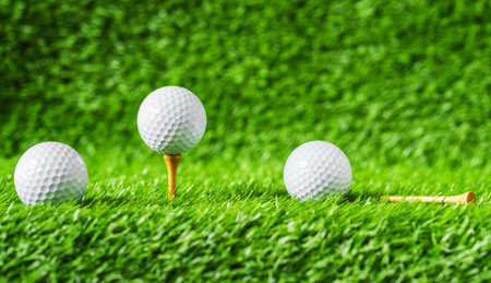 Golf ball with green grass background, on tee closeup. summer game play.の写真素材