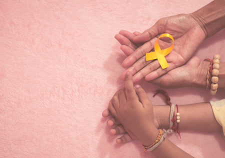 Grandma hand and grandson cancer awareness ribbon sign top view with vintage picture style.の写真素材