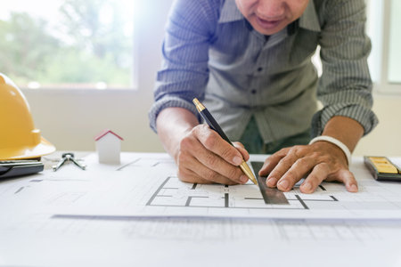 Blueprints of designer and engineers working at architects office desk.