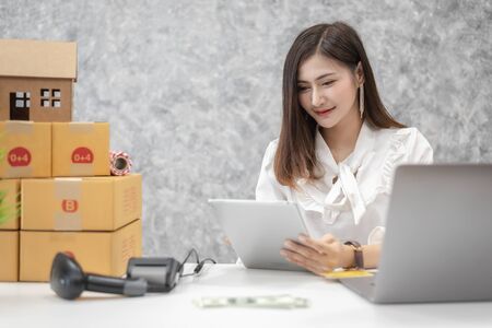 Young Asian female start up small business entrepreneur SME delivery service, with cardboard box.の写真素材