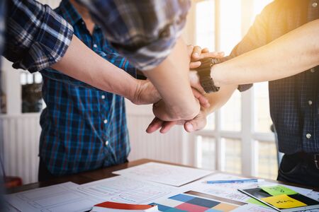 UX/UI Designers joining hands to motivate collaboration after successfully completed the target set.の写真素材