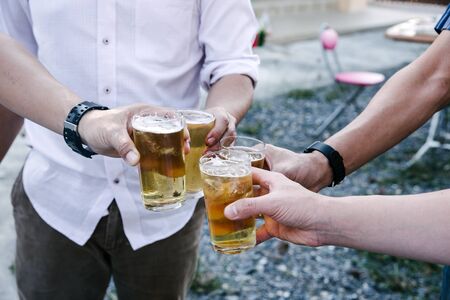 Group of happy friends drinking and toasting beer at bbq party asian person.の写真素材