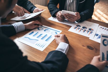 Business meeting partners discussing paperwork busy financial matter group, vintage film tone.の写真素材