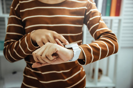 Female accountant looking time at hand watches in modern office dreaming about weekend vacation...