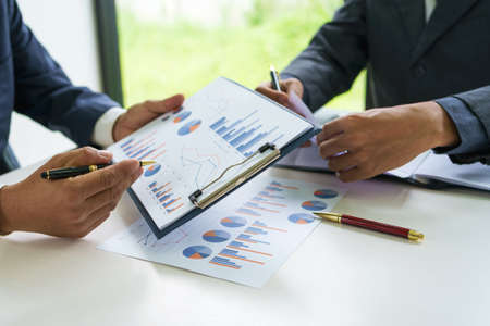 Business men and colleagues are discussing investments and graphs together in the office, teamwork concept.の写真素材