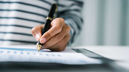 Close up hands of business woman secretary sign on paperwork financial presentation at desk.の写真素材