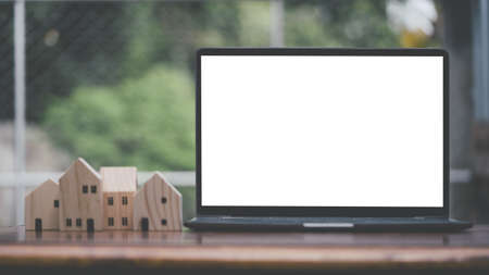 Blank screen white color laptop with blurry background, object put on desk table, mock up.の写真素材