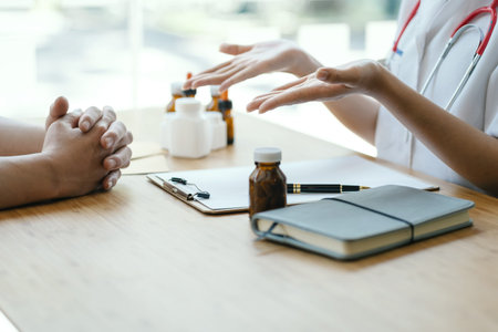 Female doctor taking a patient history, close up at hands of patient.