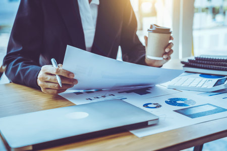 Close up business woman hands checking and analysing financial report, busy at desk, holding craft...