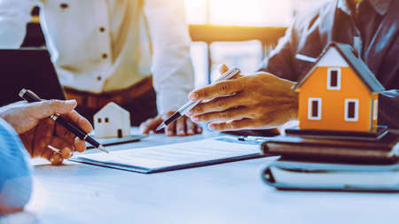 Real-estate agent sign for home contract property for sale in the office with buyer.の写真素材