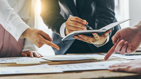 Three of business people working together in the meeting room office with paper charts, discussing and planning concept.の写真素材