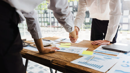Young start up businessman and woman shaking hands in the office working together as a team.