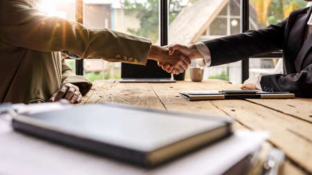 Close up business people partner shaking hands successful after a good deal briefing, working together.の写真素材