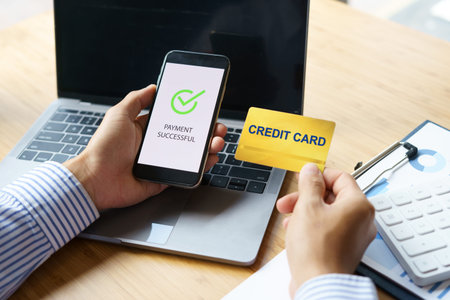 Online payment, Man hands holding smartphone and using credit card for online shopping.